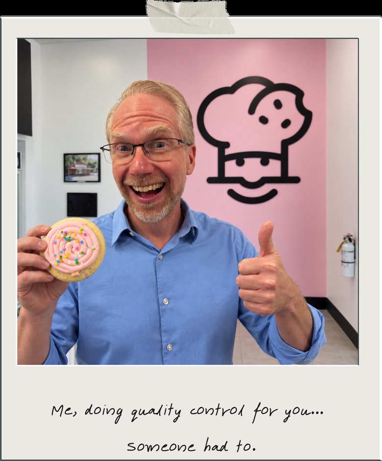 Nathan Whittacre, CEO of Stimulus Technologies, smiling and giving a thumbs up while holding a frosted cookie